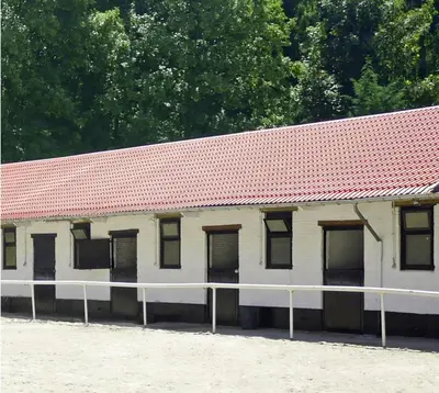an old white building with a red roof at Royal Horses in Overijse