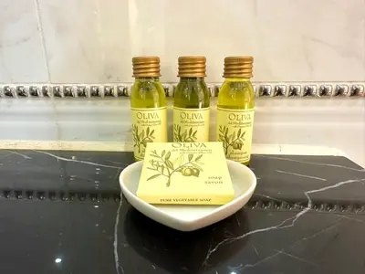 three bottles of olive oil and a book on a plate at Royal Horses in Overijse