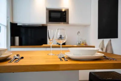 a table with two wine glasses and plates on it at Beautiful cosy apartments in the heart of Antwerp in Antwerp