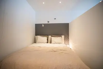 a small bedroom with a bed in the corner at Beautiful cosy apartments in the heart of Antwerp in Antwerp