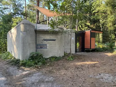 a concrete building with a door in the woods at TerraVenturia - Defcamp in Rixensart