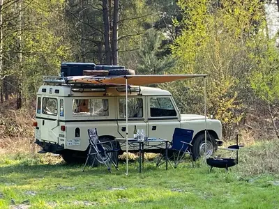 a white van with a table and surfboard on top at TerraVenturia - Defcamp in Rixensart