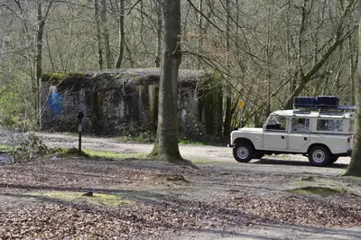 a white jeep driving down a dirt road at TerraVenturia - Defcamp in Rixensart