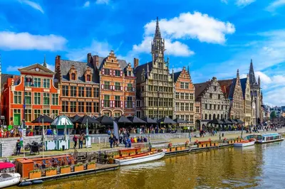 a group of buildings next to a river with boats at Phoenix in Ghent