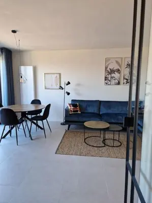 a living room with a blue couch and tables at Phoenix in Ghent
