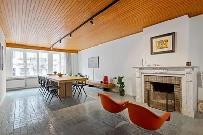 a living room with a fireplace and a table and chairs at Ramón Studio in Antwerp