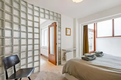 a bedroom with a bed and a chair and a window at Ramón Studio in Antwerp