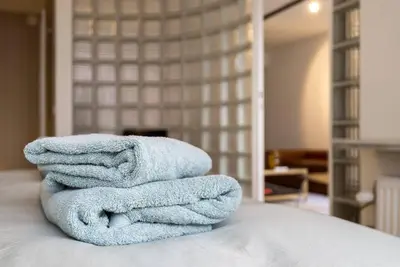 a stack of towels sitting on top of a bed at Ramón Studio in Antwerp