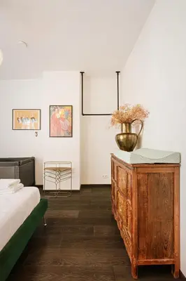 a bedroom with a bed and a dresser with a vase on it at Unbeatable Location Explore Ghent on Foot! in Ghent