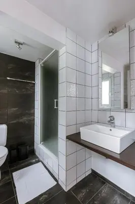 a white bathroom with a sink and a mirror at Unbeatable Location Explore Ghent on Foot! in Ghent