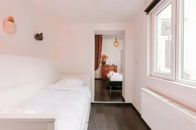a white bedroom with a bed and a window at Unbeatable Location Explore Ghent on Foot! in Ghent