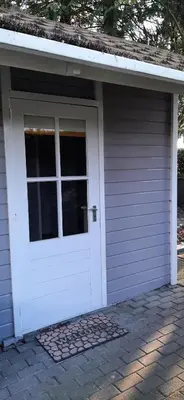 a garage with a white door on a house at Kamer 22 Bed & Breakfast in Poppel