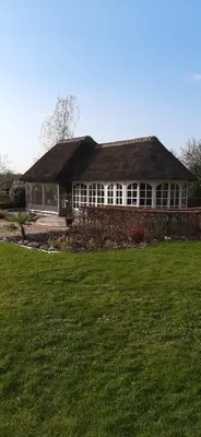 a house with a grass field in front of it at Kamer 22 Bed & Breakfast in Poppel