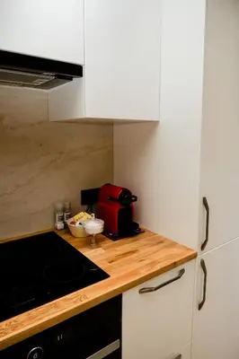 a kitchen with white cabinets and a red bag on the counter at Beauty Suite in Brussels