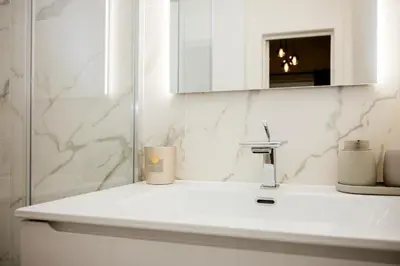 a white bathroom with a sink and a mirror at Beauty Suite in Brussels