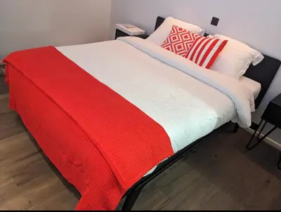 a bed with a red and white blanket and pillows at luxe en authenticiteit in Antwerp