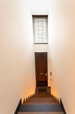 a hallway with stairs with a door and a window at luxe en authenticiteit in Antwerp