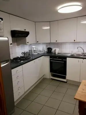 a kitchen with white cabinets and a black appliance at Triplex près de la Grand-Place in Brussels