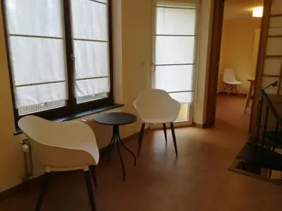 a room with white chairs and a table and windows at Triplex près de la Grand-Place in Brussels