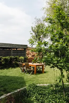 a picnic table and two chairs in the grass at Bijgebouw hoeve in landelijke omgeving in Putte