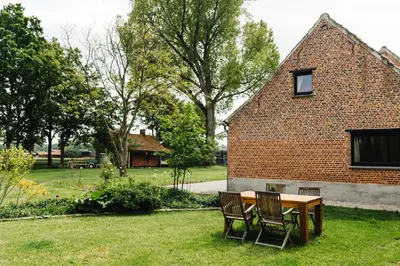 a table and chairs in the yard of a house at Bijgebouw hoeve in landelijke omgeving in Putte